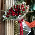 دسته گل رز هلندی قرمز با بسته‌بندی شیک و روبان ساتن از گلفروشی فلورانس