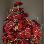 گلدان گل آنتریوم زرشکی در کنار پنجره با نور طبیعی