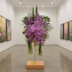 "استند گل هنری گالری گل فلورانس با گل‌های ارکیده بنفش و طراحی مدرن طلایی برای دکوراسیون داخلی"