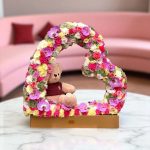 "با فریم قلب وارونه، گل‌ها و عروسک‌ها در یک طراحی قلبی و شیک قرار گرفته‌اند تا هدیه‌ای منحصر به فرد برای عزیزانتان باشد. این محصول زیبا، حس خاص و رمانتیک را به هر مناسبت می‌آورد."