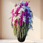 جام گل ارکیده گرند با ترکیب گل‌های ارکیده سفید و بنفش در گلدانی شیک و مدرن