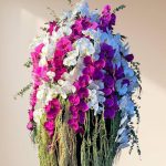 جام گل ارکیده گرند با گل‌های ارکیده سفید و بنفش در یک گلدان شیک و مدرن