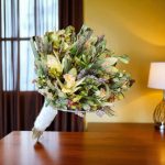 دسته گل عروس فرمالیته با گل‌های ارکیده سبز و طراحی خاص برای عروسی‌های خاص.