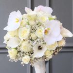 "دسته گل عروس وایت با گل‌های رز سفید، ارکیده و لیلیوم، انتخابی شیک و لوکس برای روز عروسی شما."