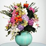 گل رومیزی فیروزه ای فلورانس، ترکیبی از گل‌های زیبا مانند اورکید و رز هلویی در گلدانی فیروزه‌ای است که به هر دکوری طراوت و زیبایی خاصی می‌بخشد. این گلدان شیک، مناسب برای تزئین فضای داخلی و هدیه دادن به عزیزانتان می‌باشد.