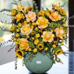 دسته گل رو میزی تم زرد با گل‌های آفتابگردان و رز زرد، مناسب برای فضاهای شاد.