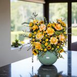 دسته گل رو میزی تم زرد با گل‌های رنگارنگ و شاد، مناسب برای تزئینات میز.