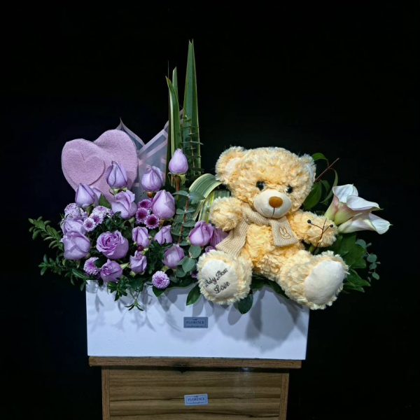 باکس 50 سانت نیلی با رز بنفش ولنتاین - باکس غول‌پیکر ۵۰ سانتی به رنگ نیلی سلطنتی، رز بنفش هلندی شاخه‌بلند، گل‌های فصلی بنفش و روبان ساتن از گلفروشی فلورانس