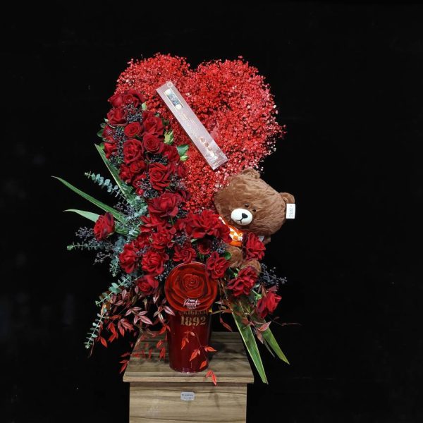 سطل قرمز با رز قرمز با دیزاین ولنتاین - باکس سطلی مینیمال قرمز با طرح قلب، رز هلندی شاخه بلند و روبان ساتن، هدیه دکوراتیو ولنتاین از گلفروشی فلورانس